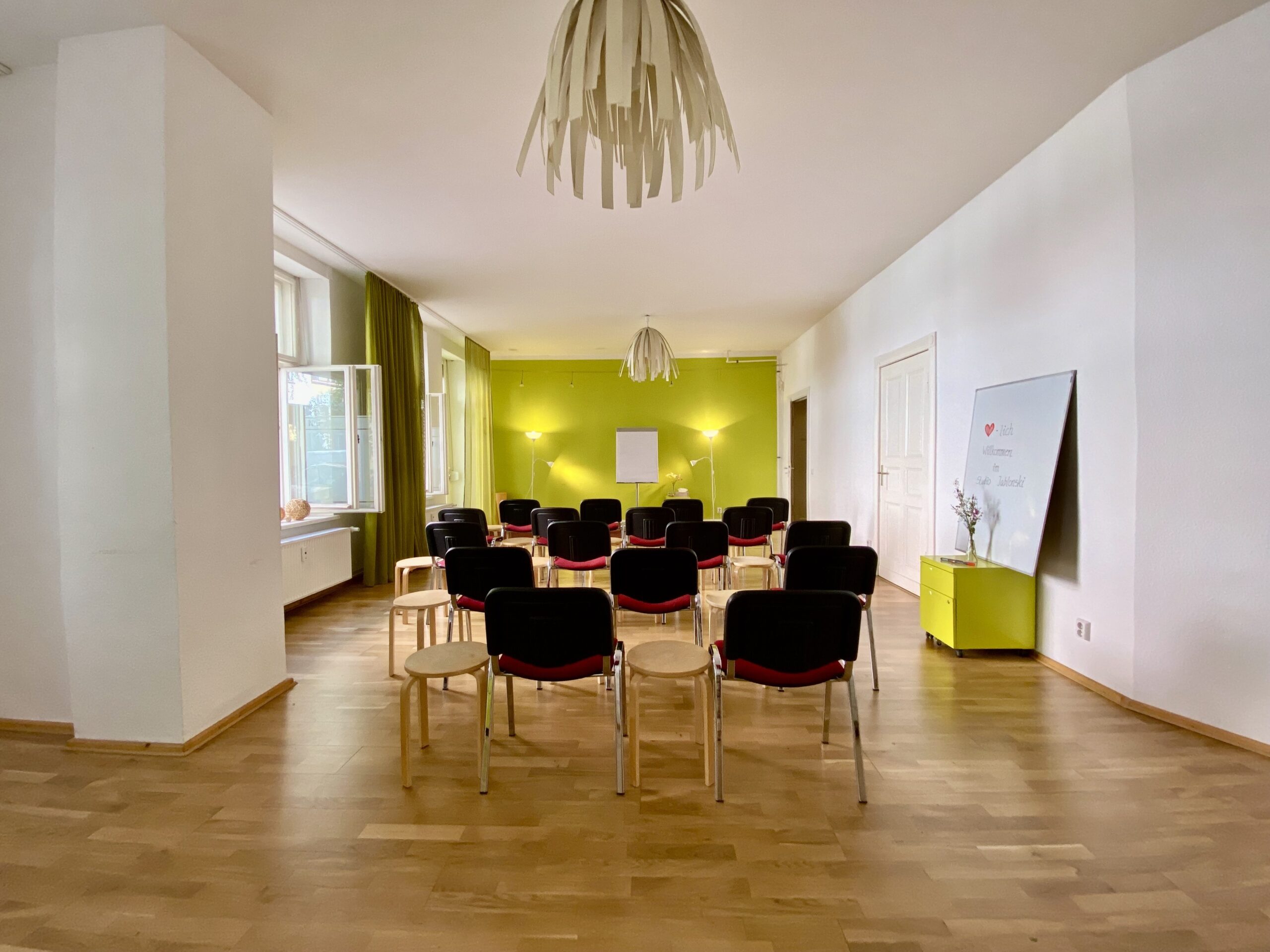 Grüner Saal mit Reihen- und Hockerbestuhlung, heller Seminarraum im Studio Jablonski Berlin
